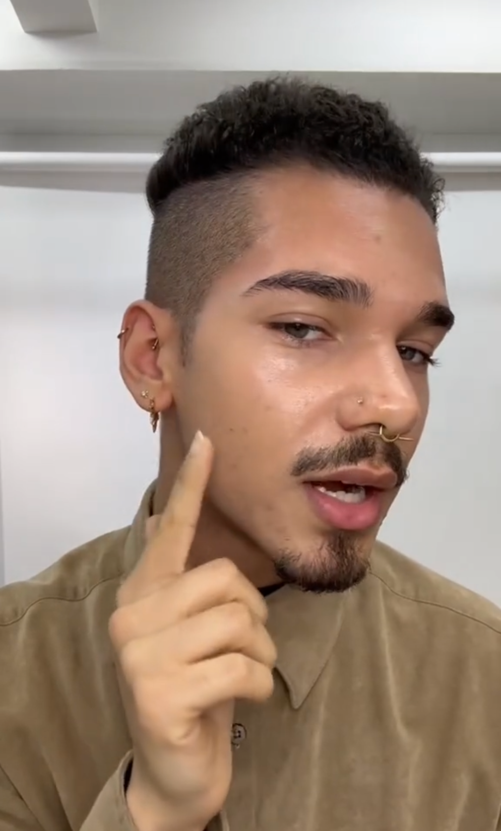 a man showing already applied foundation on his face and how it is a perfect match for his skin tone